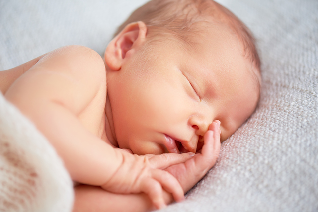 Cute newborn baby sleeps in white